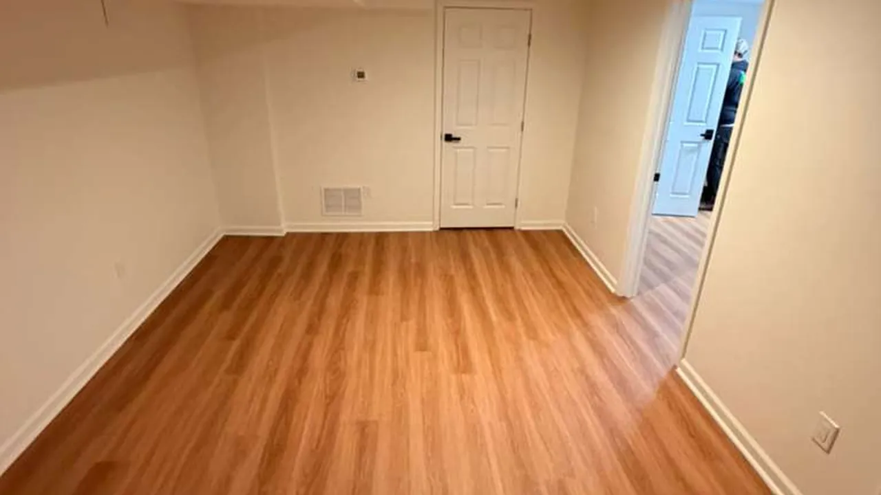 Empty bedroom with clean hardwood floors and bare walls at the end of a tenancy