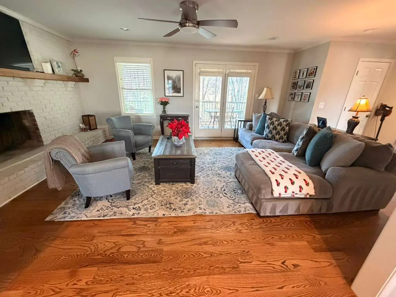 Living room with hardwood floors, a patterned rug and a sectional sofa after a North Cleaning ATL visit